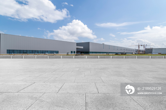 Empty square floor tiles and modern factory buildings and warehouses..