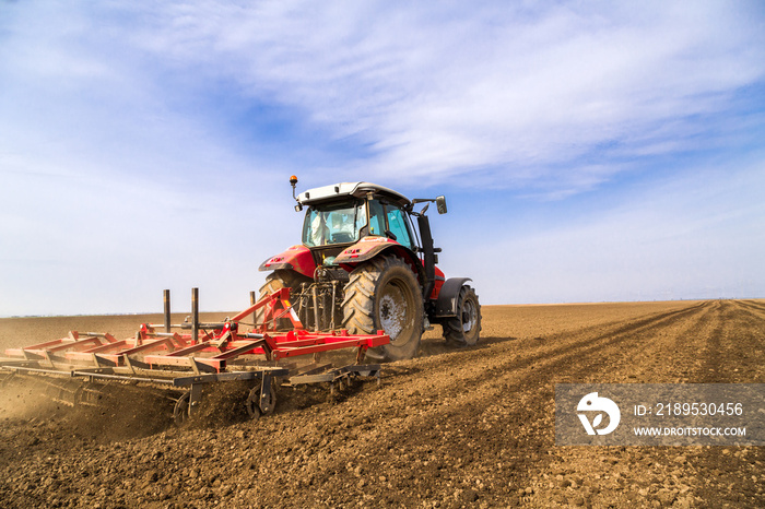 Farmer in tractor preparing land with seedbed cultivator