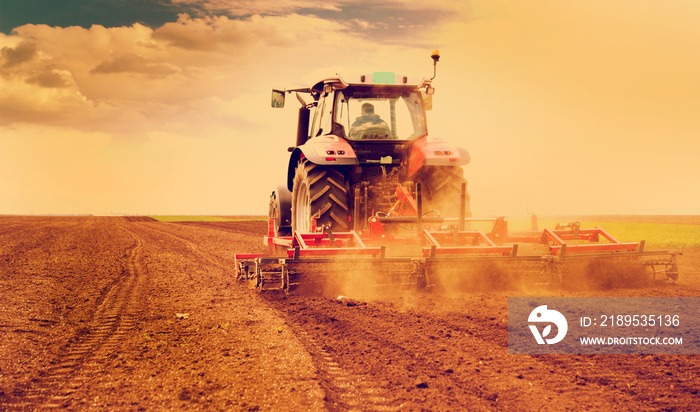 Farmer in tractor preparing land for sowing