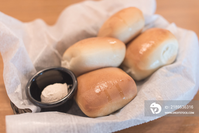 Texas Roadhouse Rolls with Cinnamon Honey Butter in a basket.;