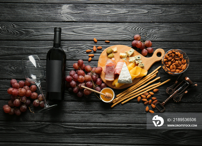 Composition with bottle of wine on dark wooden background