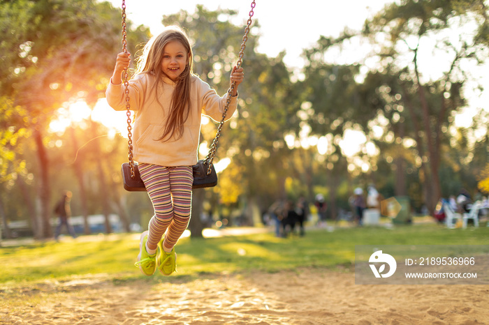 Girl holding chains of swings and swinging