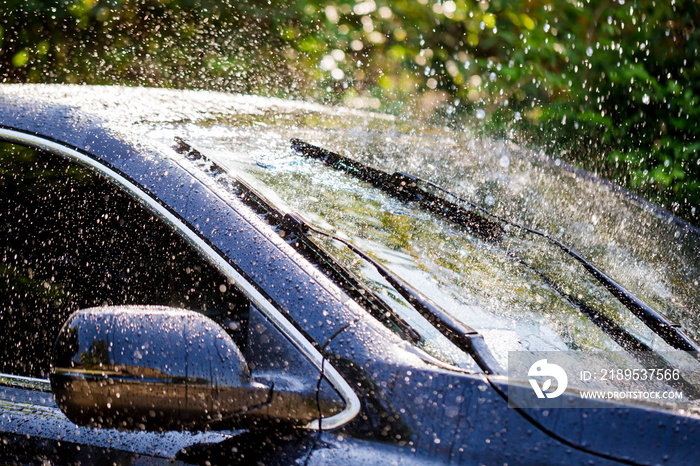 Car windshield with rain drops and frameless wiper blade