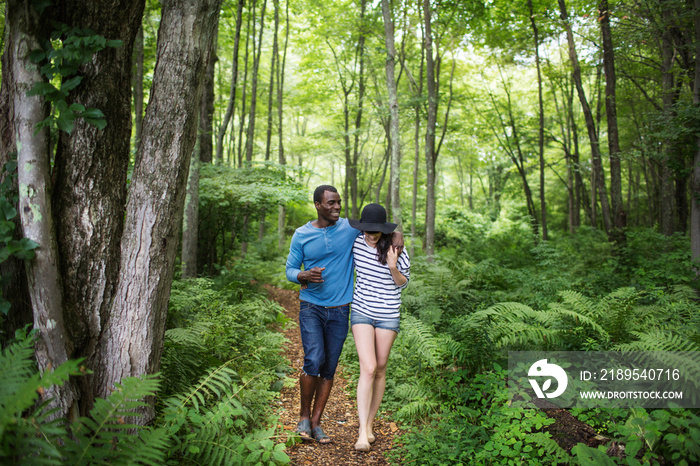 Mid-adult couple walking through forest