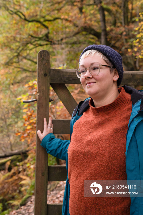 Female hiker walking through gate in forest