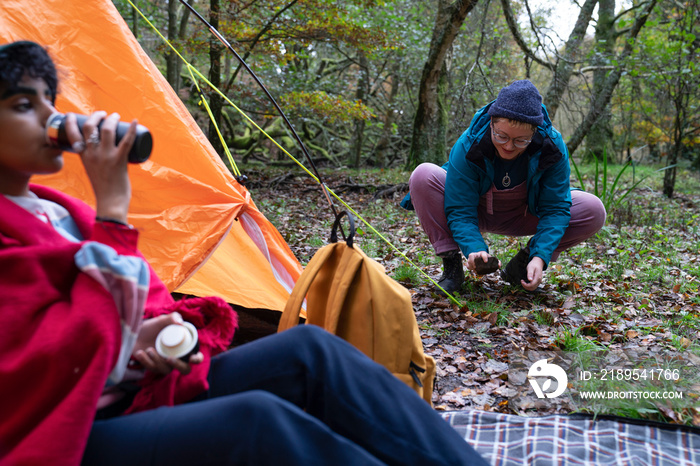 Women setting camp in forest