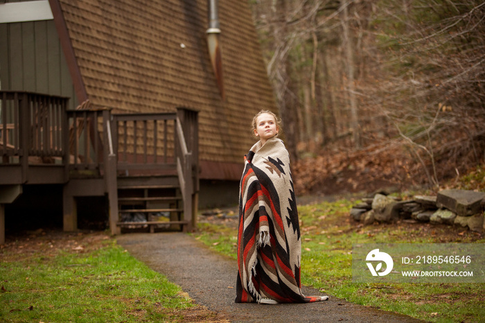 Thoughtful girl wrapped in blanket