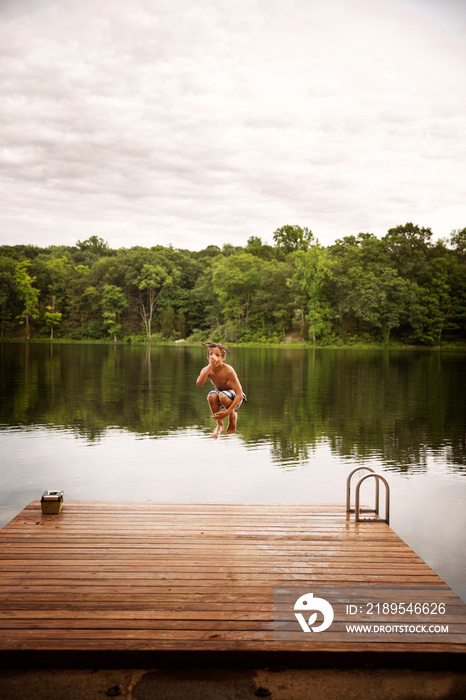 Boy jumping in lake