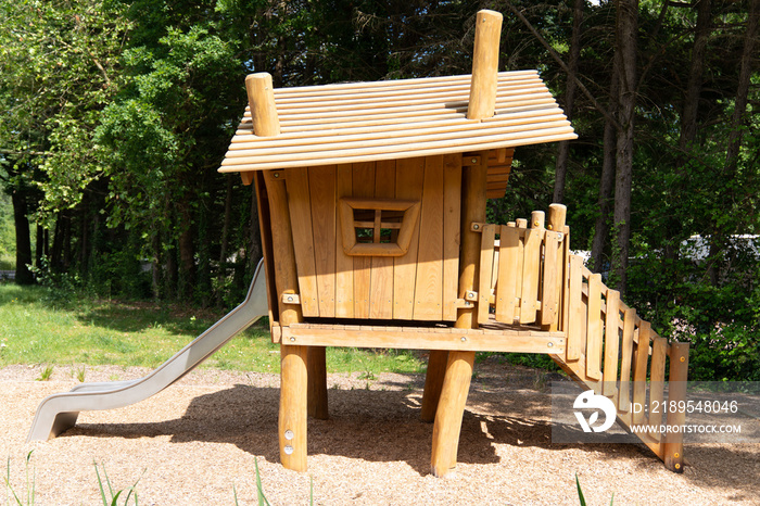 little wooden playhouse in a public park with stairs and windows