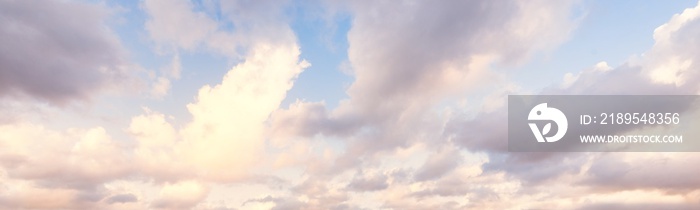 Clear blue sky. glowing pink and golden cirrus and cumulus clouds after storm, soft sunlight. Dramat