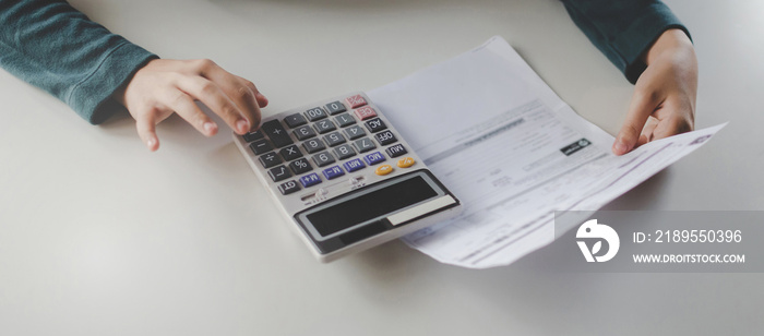 wide banner. young woman using calculator for analysis and calculate family budget cost bills report