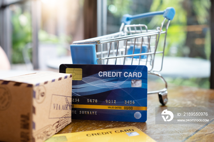 Shopping cart with credit card and box on the table within coffee shop.