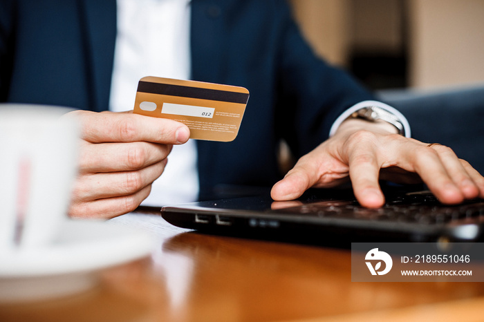 Close up photo of mans hands using credit card and purchasing something on sale.