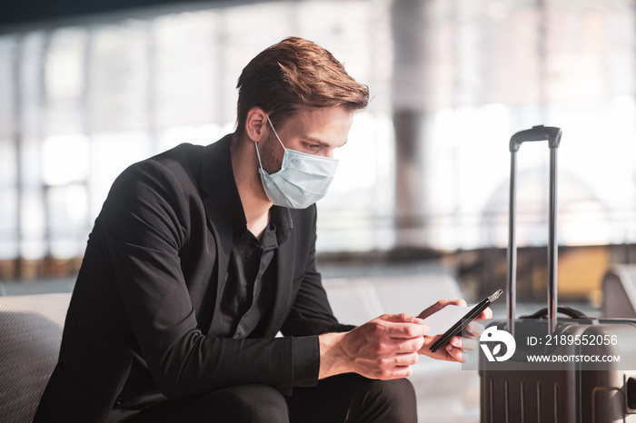 Man wearing a face mask and holding his boarding pass