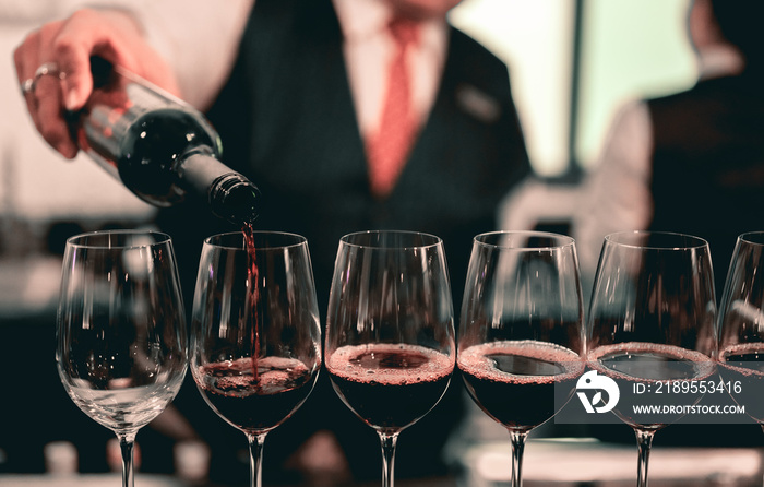 Bartender pouring red wine into a wine glass..Restaurant, beverage, alcoholic beverage concept.