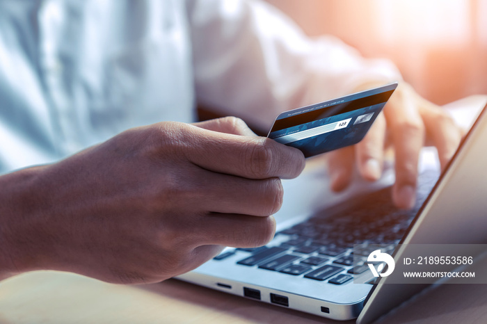 Young man use credit card for shopping payment online on laptop computer application or website. E-c