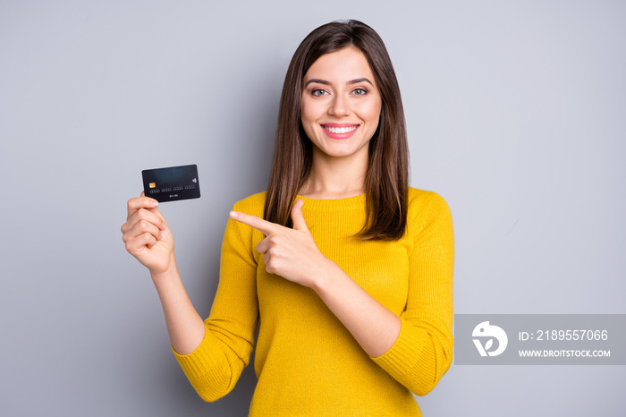 Portrait of lovely glad cheerful girl holding in hands demonstrating bank card solution isolated ove