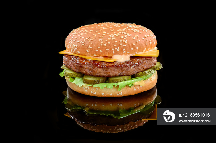 Big tasty hamburger or cheeseburger on black background