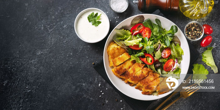 Delicious breaded codfish with salad in a plate