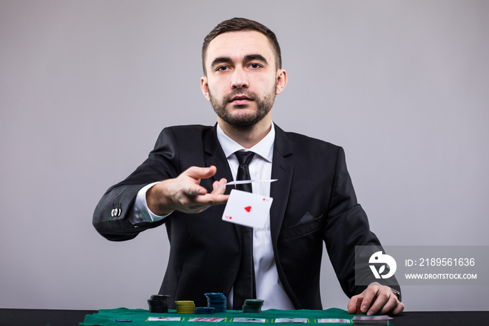 Poker player in suit throwing two ace cards.