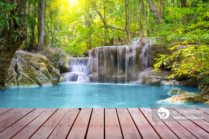 Waterfall, green forest in Erawan National Park in Thailand montage with wooden floor. Landscape wit