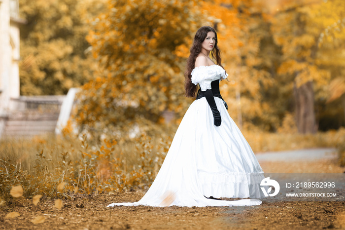 Woman in a white Victorian dress in an autumn park