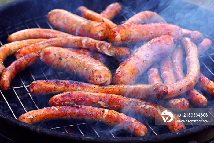 grill sausages and wieners on the grill in the smoke