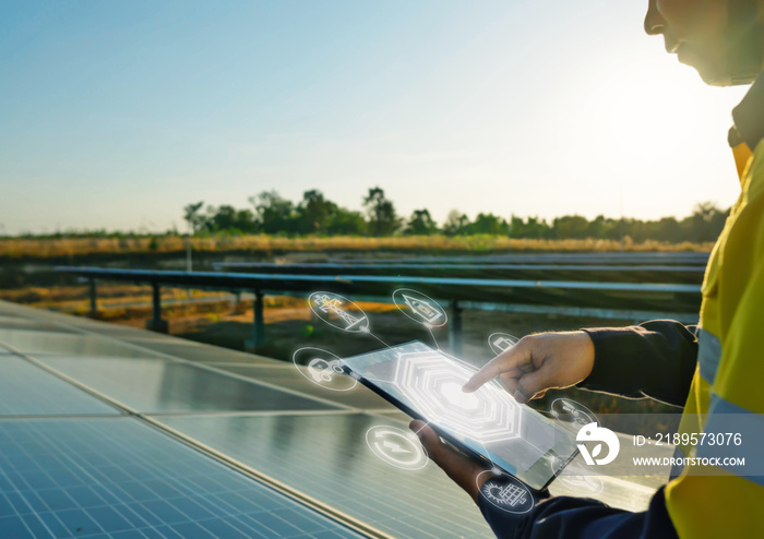 The solar farm(solar panel) with engineers is checking the operation of the system by laptop.