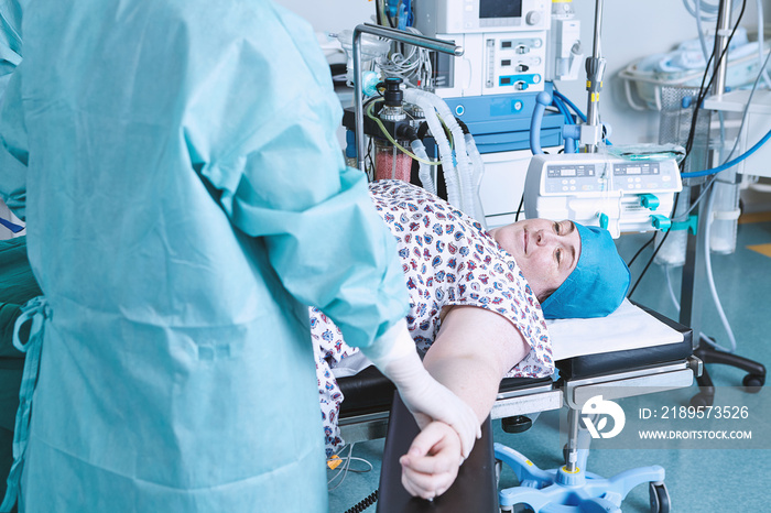 Surgeon reassuring patient in maternity ward operating theatre