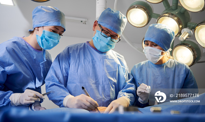 医生在病人躺在手术台上进行美容手术。外科医生和助手