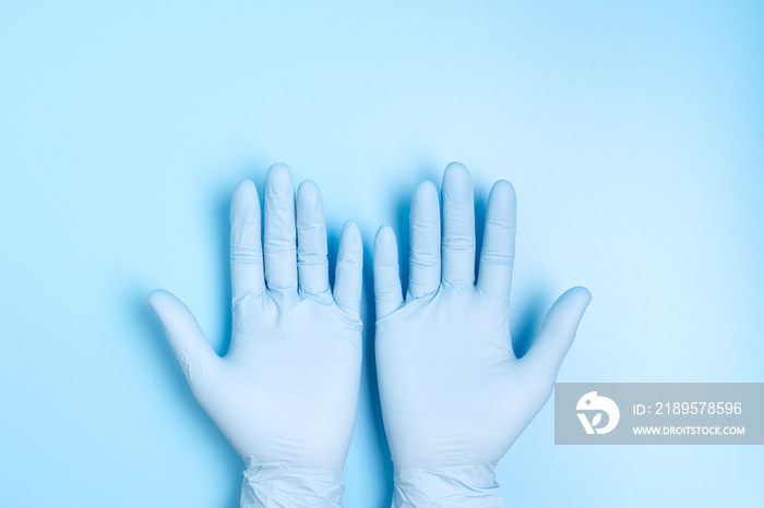 蓝色背景下隔离的医用乳胶手套中的两只手掌