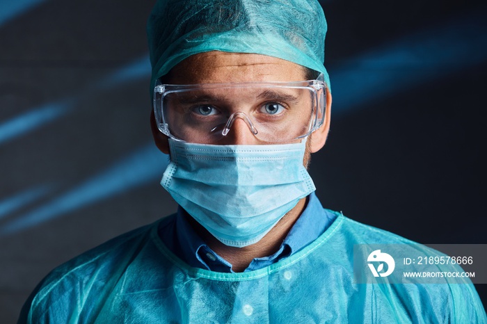 Portrait of tired good looking young doctor in protective medical face mask and glasses. Covid-19 vi