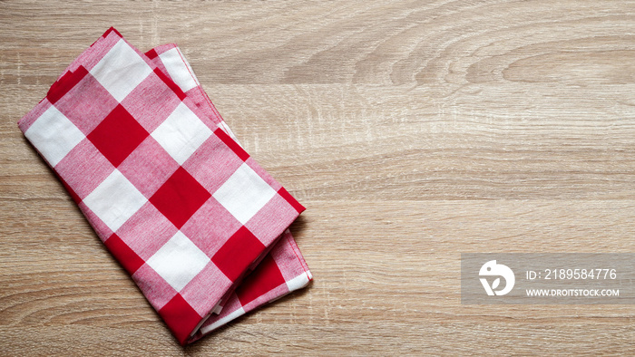 close up top view red color fabric checked tablecloth on vintage wood texture tabletop in kitchen fo