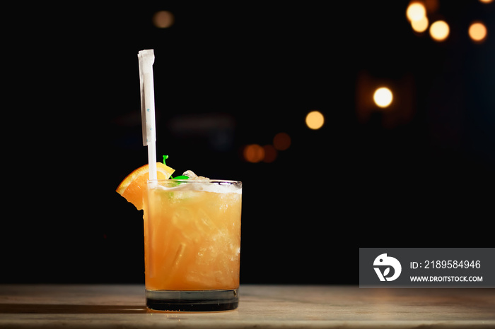 Mai Tai cocktail on bar counter with light bokeh.