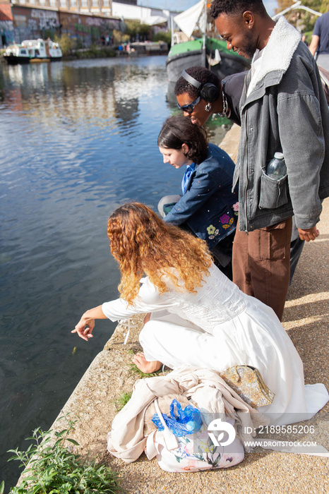 A group of transgender friends looking at the fish and ducks in the canal.