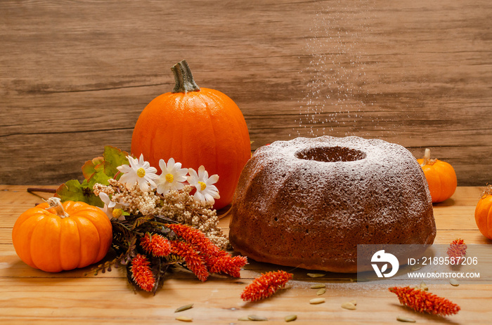 Panqué de calabaza hecho en casa sobre mesa de madera con decoración otoñal. Calabazas y flores alre