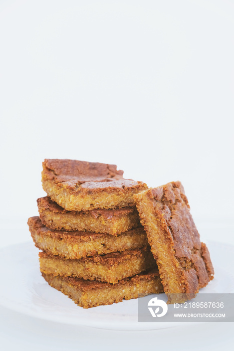 Stack of delicious freshly baked blondie brownie dessert slices, close up.