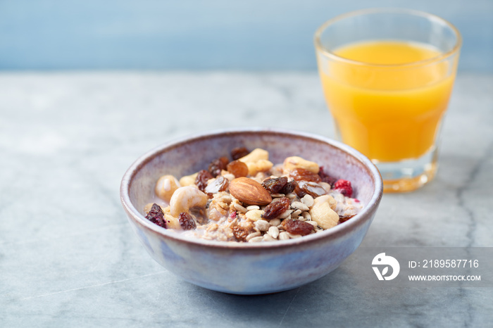 Bowl of granola with yogurt, nuts, raisins, cranberries and chia seeds. Concept for a tasty and heal