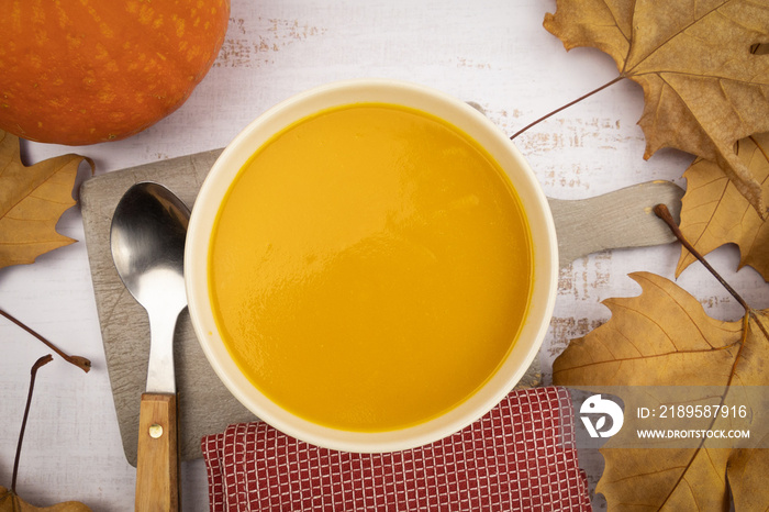 soupe au potiron avec feuilles dautomne et cuillère sur fond blanc