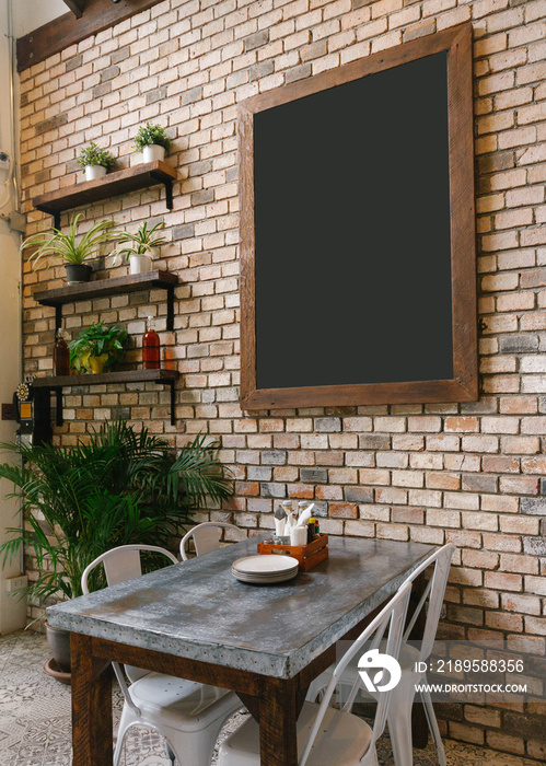 Empty Black Board on Brick Wall and Dinning Table in below.
