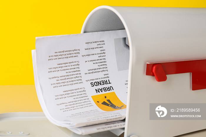 Mail box with newspapers on color background, closeup