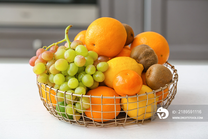 Basket with different fruits on kitchen table