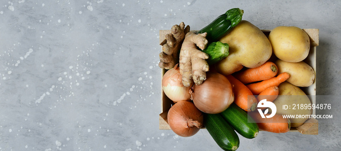 bio potatoes, carrots, zucchini, onions and ginger in a wooden box. Delivery fresh vegetables at hom