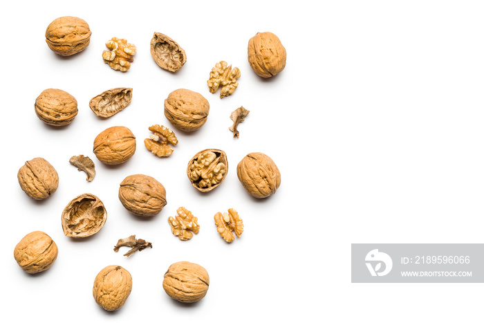 top view of walnuts closed and broken scattered on a white background with copy space