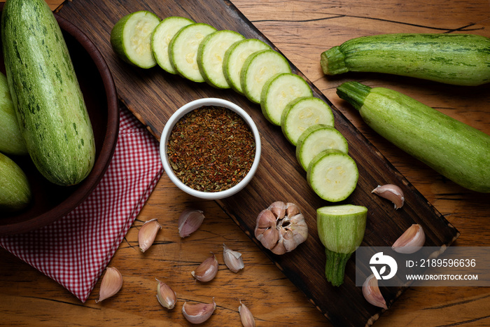 zucchini slices on wooden board garlic pepper and seasonings