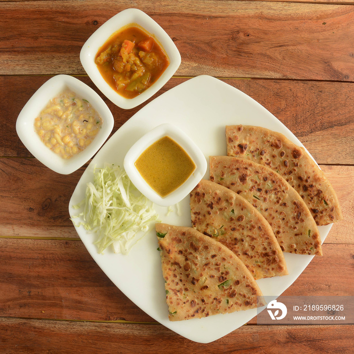 Aloo Paratha or Indian Potato stuffed Flatbread. Served with fresh curd, veg gravy and salad. isolat