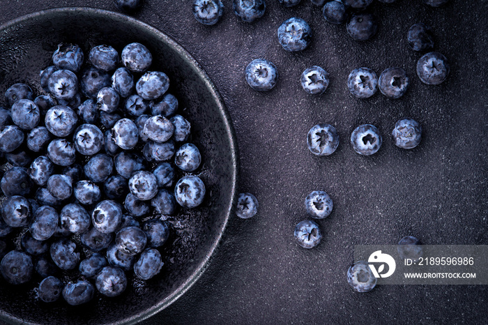 fresh picked blueberries on black stone background