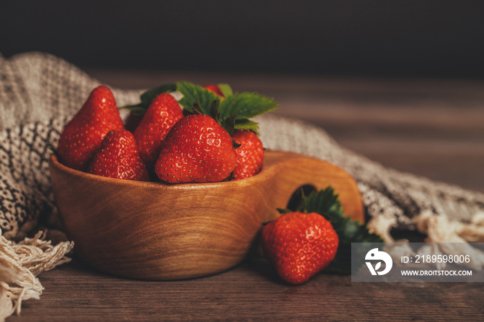 Fresh strawberries with leaves in wooden bowl