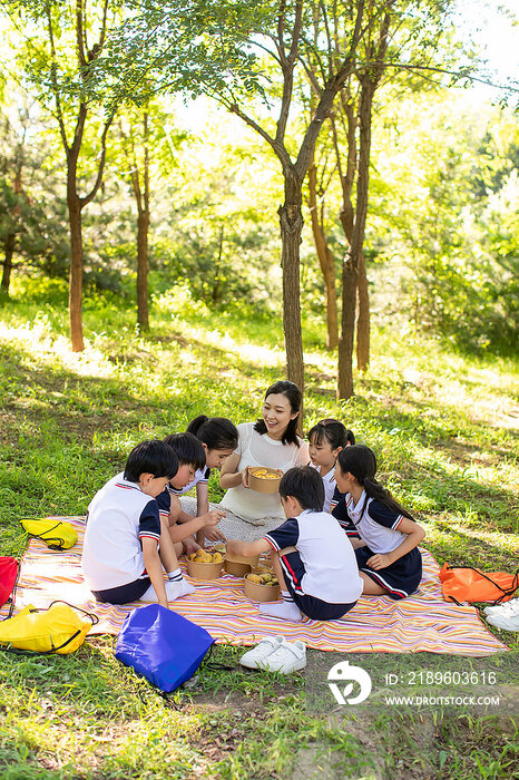 快乐的小学生和老师在户外野餐