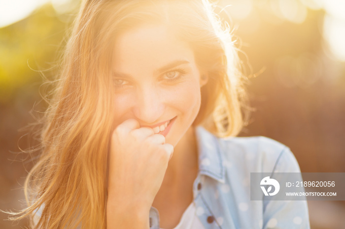 Gorgeous girl with a beautiful smile and sunrays reflected on her happy face